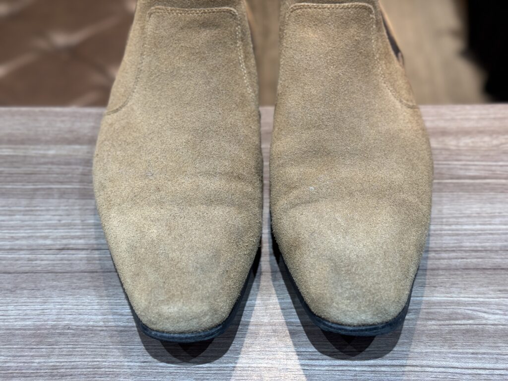 ベージュスエードブーツのトゥ部分。うっすらとした黒ずみが見られるクリーニング前の状態。