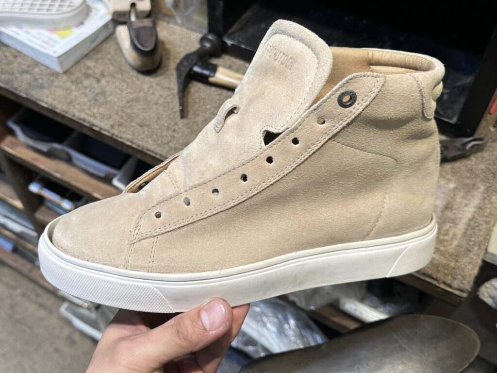 ビルケンシュトックのスニーカーに、候補となるソールを仮合わせしている場面。形や色の相性を確認しながら選定を進めている様子。