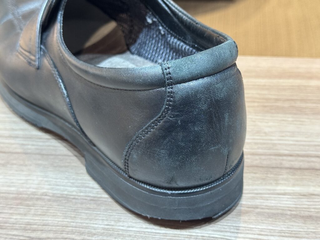 ローファーの履き口外側。擦れによる色抜けが見られる補修前の状態。