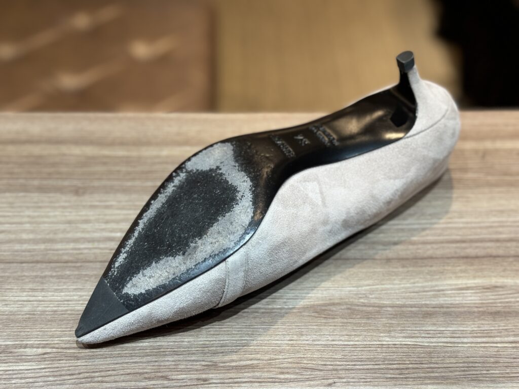 修理前のアウトソール。前半分の摩耗が進み、薄くなった面が見える。