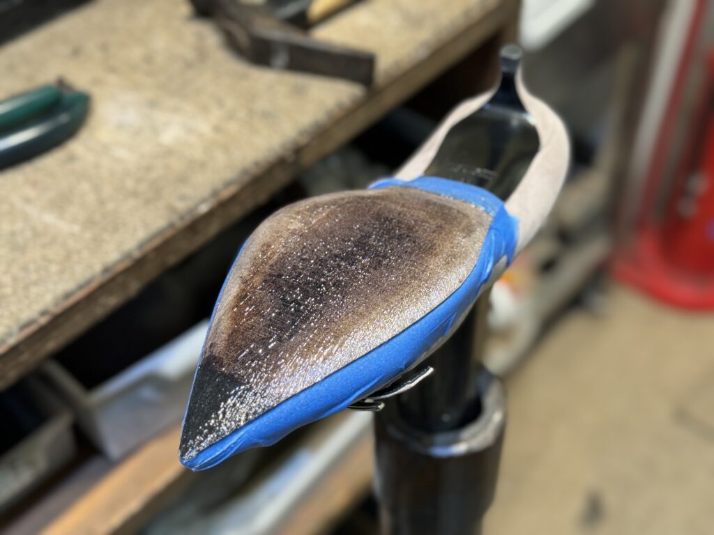 接着剤塗布後、スエードアッパーに付着しないよう青テープでマスキングして作業中。