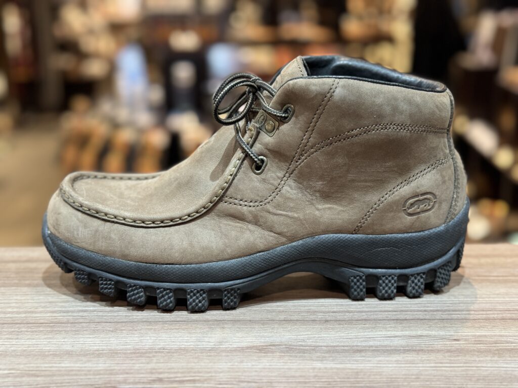 修理前のブーツ全体を側面から撮影した写真。使用によるソール摩耗が見られる。