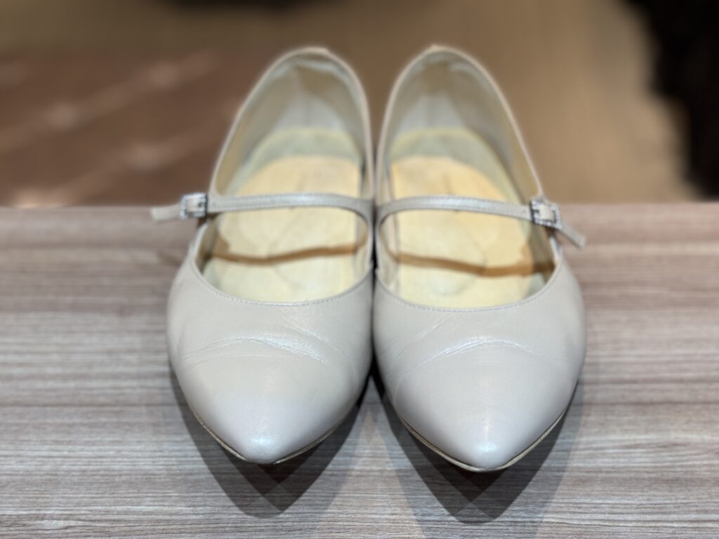 つま先の色と質感が自然に馴染んだ補修後のポインテッドトーパンプスを正面から写した完成状態