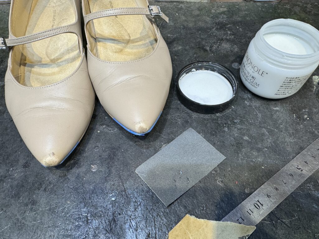 つま先キズ補修に使用する資材と、下地を整える途中段階のポインテッドトーパンプス