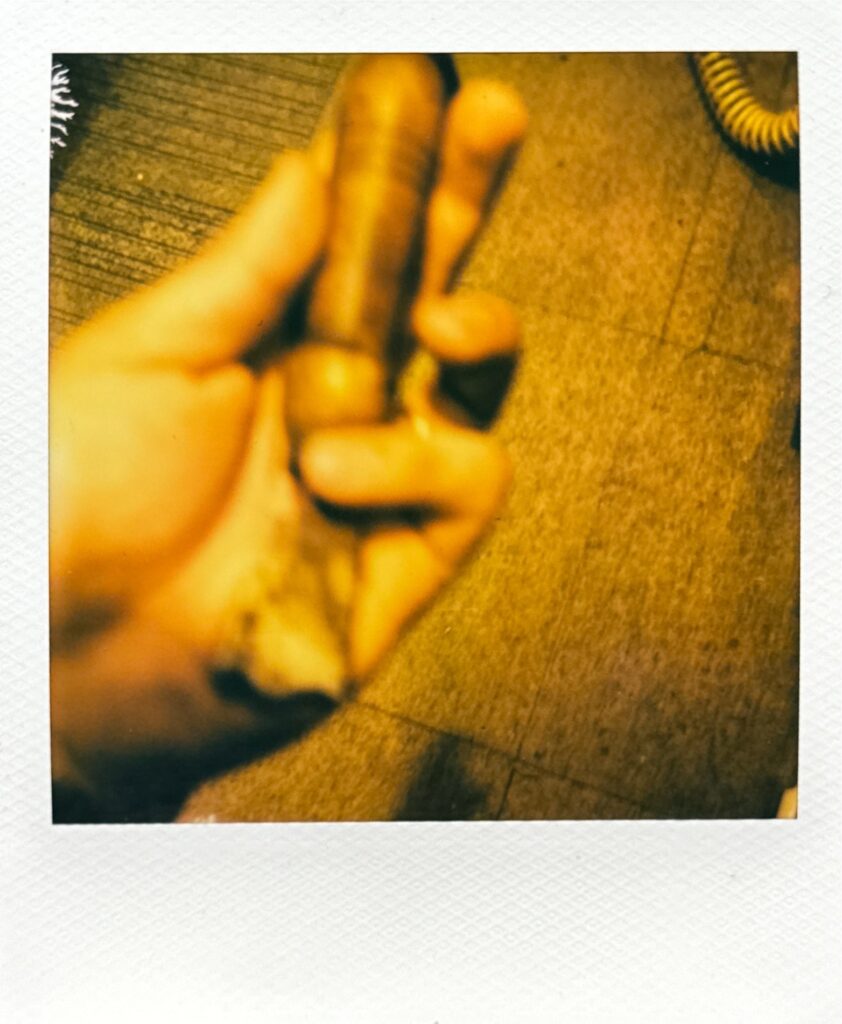 靴修理用のコバコテを手に持つ作業中のポラロイド写真