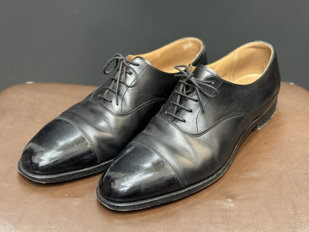 ケア前のクロケット&ジョーンズ。全体にくすみが見られる黒のストレートチップ。