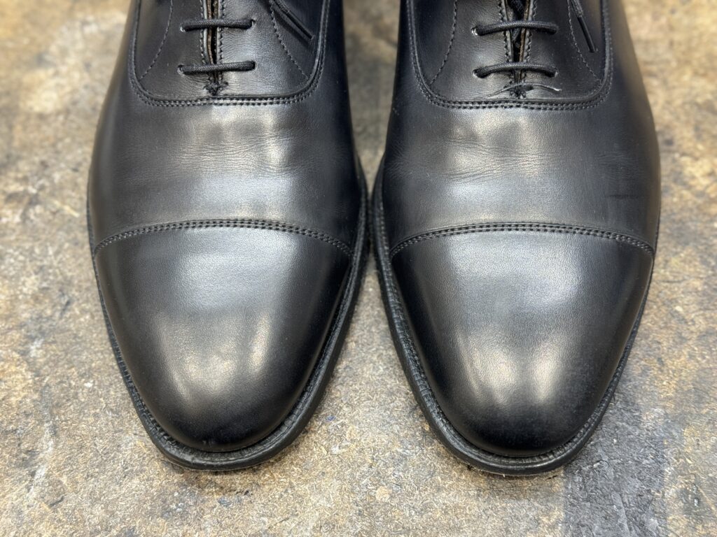 古いワックス層をクリーナーで落としたクロケット&ジョーンズのつま先。素の革質が見える状態。