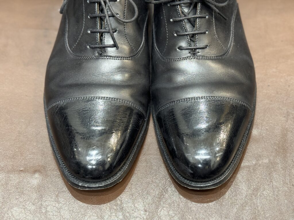 つま先の鏡面ワックスがひび割れたクロケット&ジョーンズ。磨き直し前の状態。