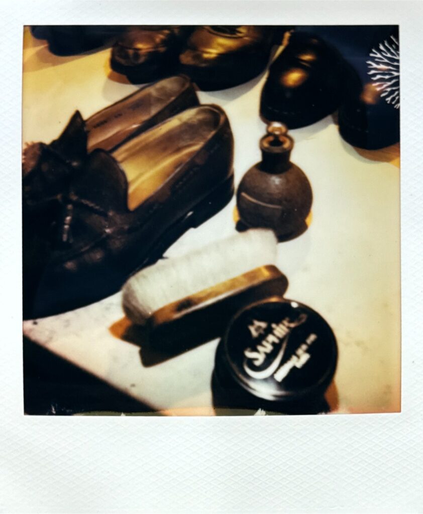 ポラロイド写真。ローファーと靴磨き道具が並ぶ温かみのあるカット
