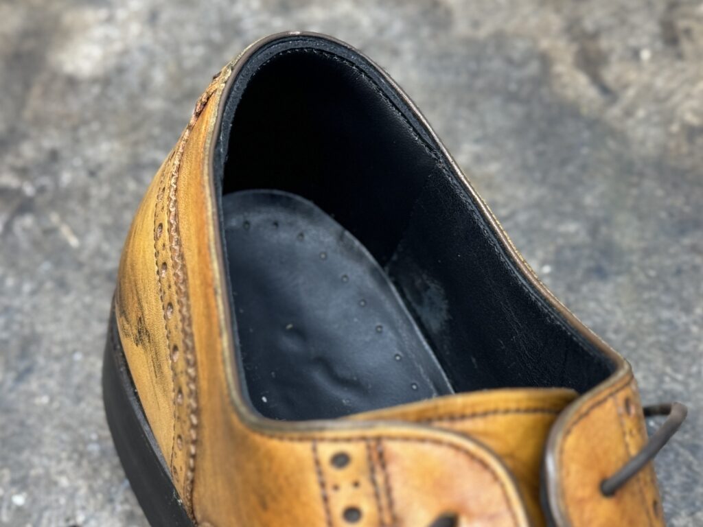 補修革を薄くすいて縫い留めた修理後の履き口ライニング