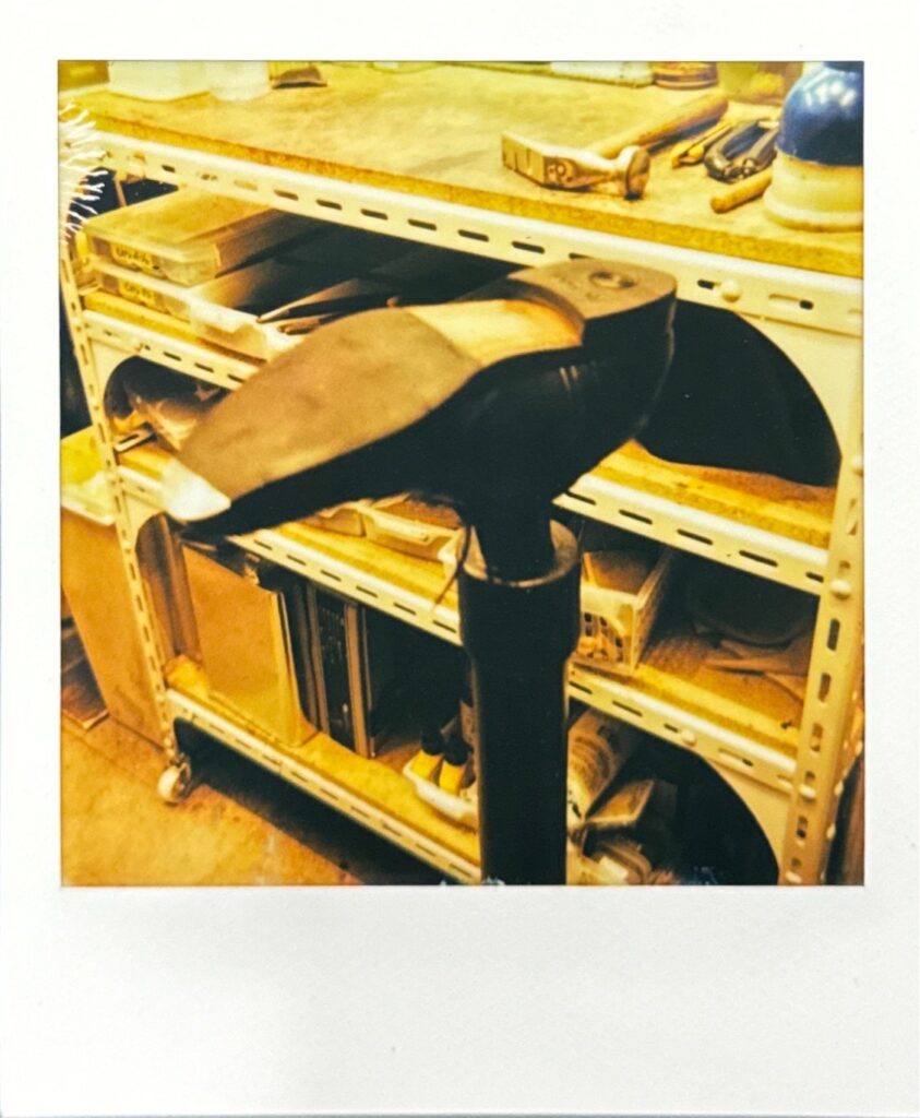 作業台に置かれた靴のポラロイド写真。修理後のトースチールと工房の雰囲気が写っている。