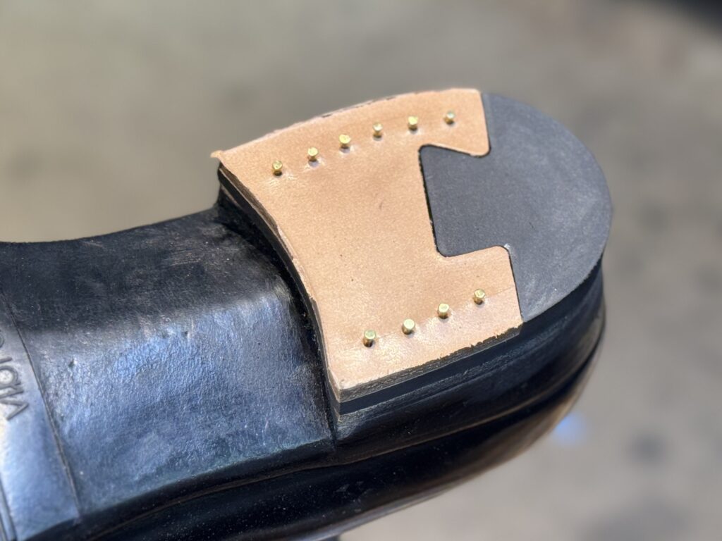 マーティンオークバーク製トップリフトに飾り釘を打ち込む工程。均整を重視した配置