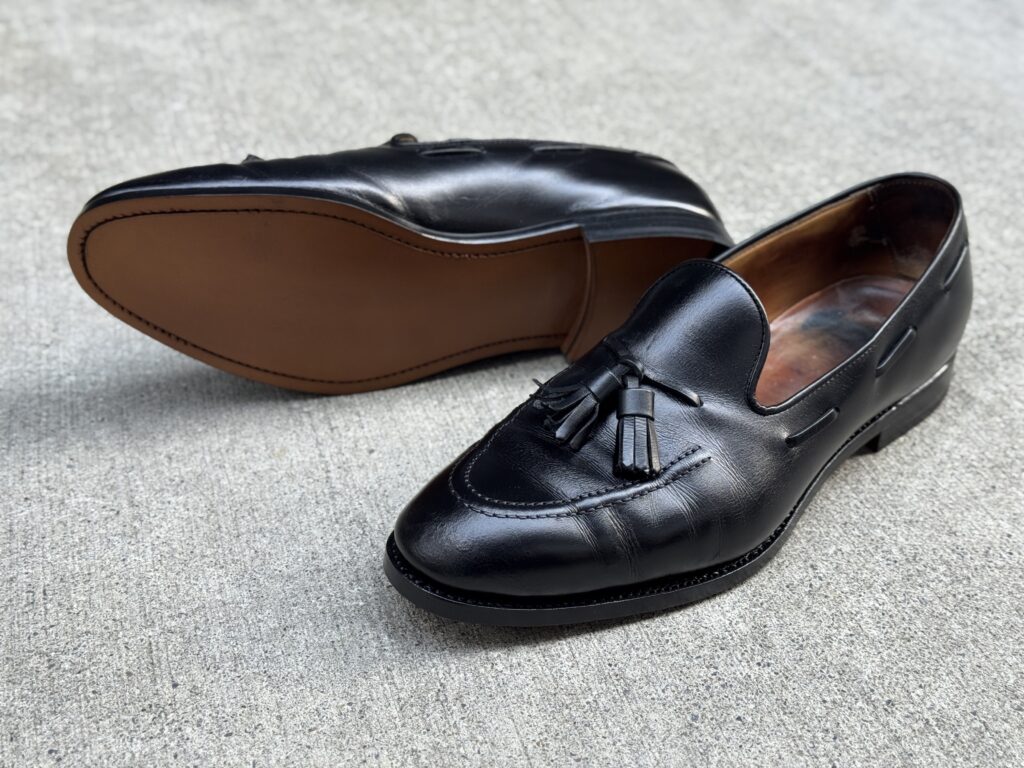 修理後のローファーを俯瞰で、ソール面も見える構図。新品同様に整えられたアウトソールが確認できる。