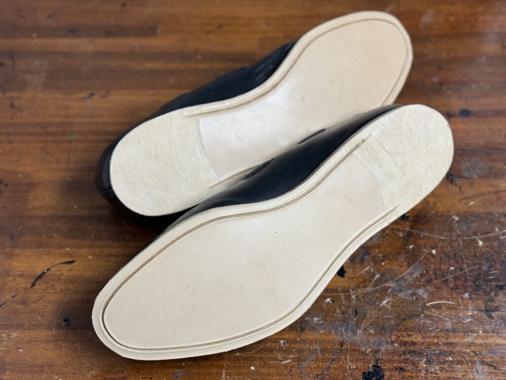 新しいレザーアウトソールを貼り付けた直後の状態。まだ仕上げ前のナチュラルなソール面が見える。