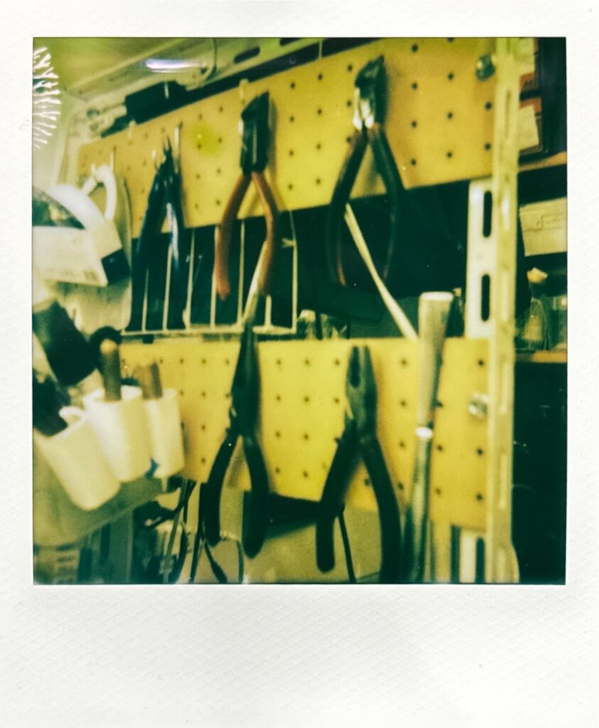 壁面に吊るされた修理工具が並ぶ作業場の一角