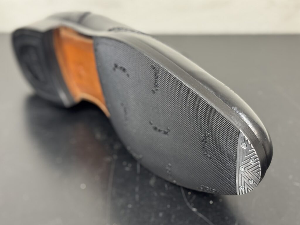 修理後のコバをソール側から撮影した写真。ハーフラバーとコバの境界が滑らかで、履き心地と耐久性を意識した仕上げになっている。