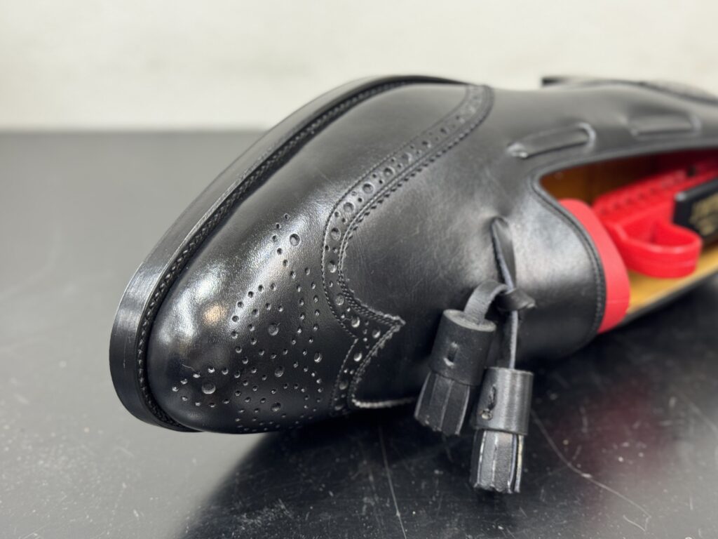 修理後のコバをアッパー側から撮影した写真。ハーフラバーの段差処理が自然で、靴本来のシルエットを損なっていない。