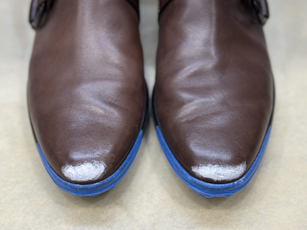 トッズのブーツのつま先傷にパテを埋めている修理工程の写真