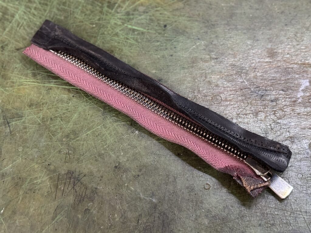 新しいファスナーに風防パーツを接着・一体化した状態（裏側の当て布と縫製）