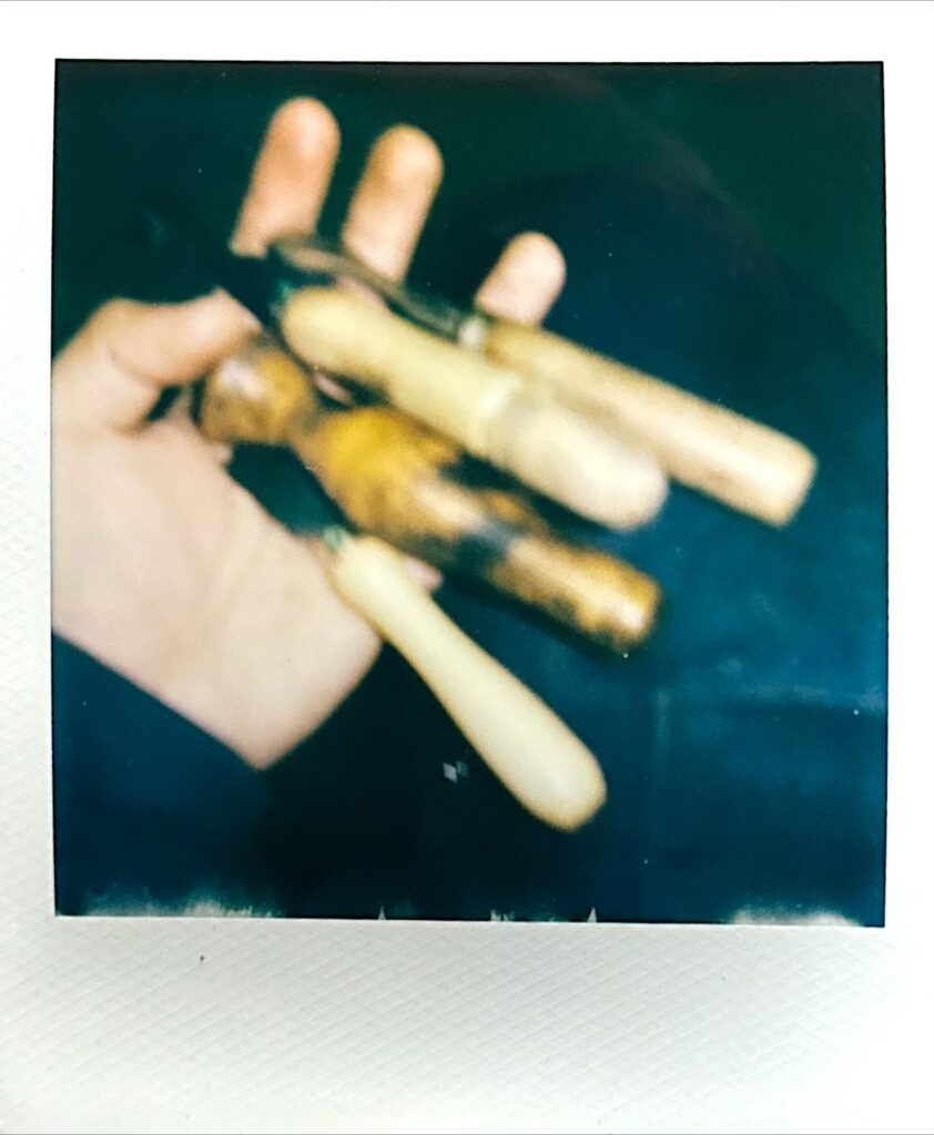 コテを手に持ったポラロイド写真 作業道具の質感表現