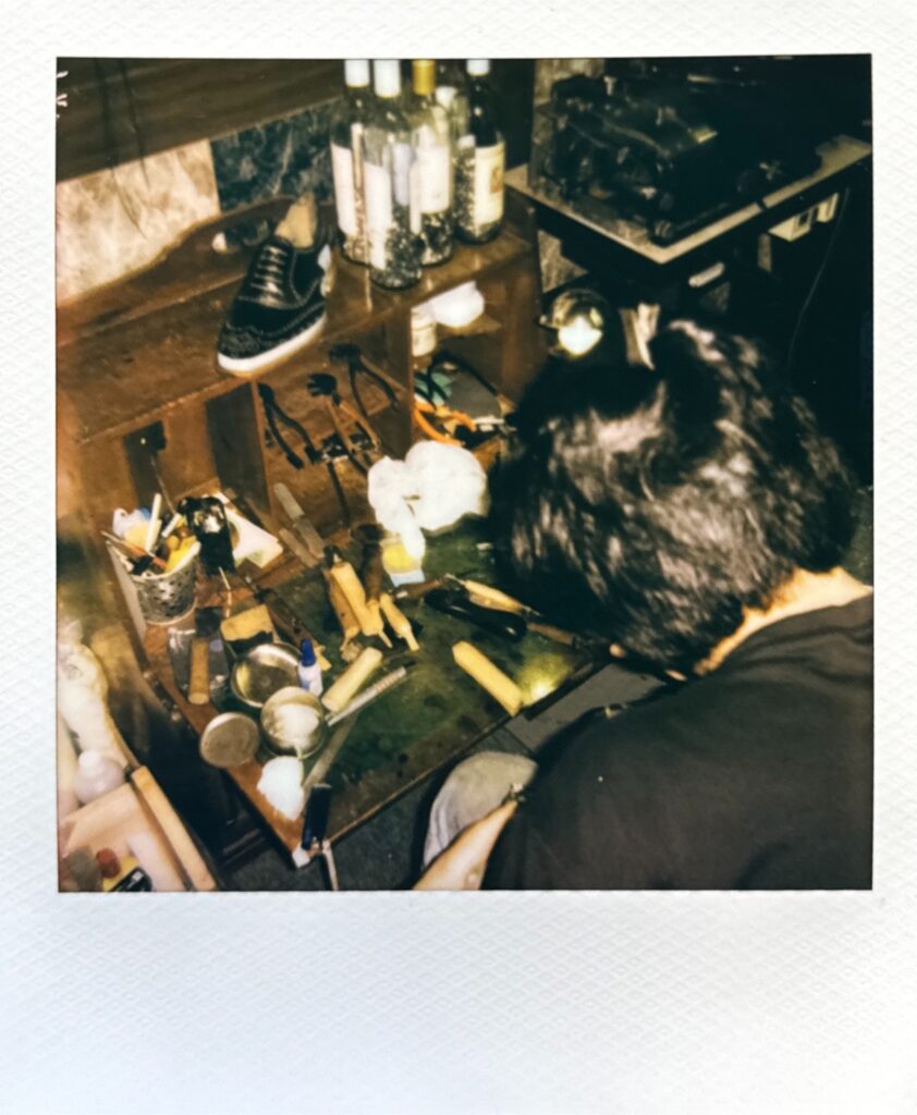 作業台に向かう靴職人のポラロイド写真